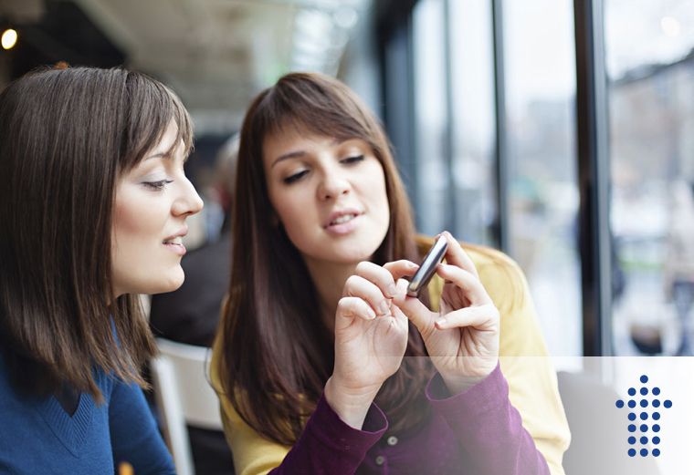 One person showing a device to another