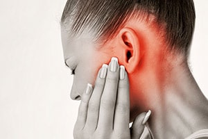 Woman holding ear in pain