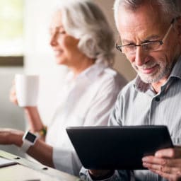 Elderly couple together wearing glasses at the kitchen
