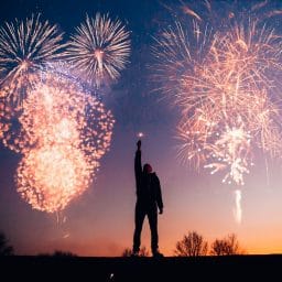 Man with fireworks in his hand and fireworks in the air