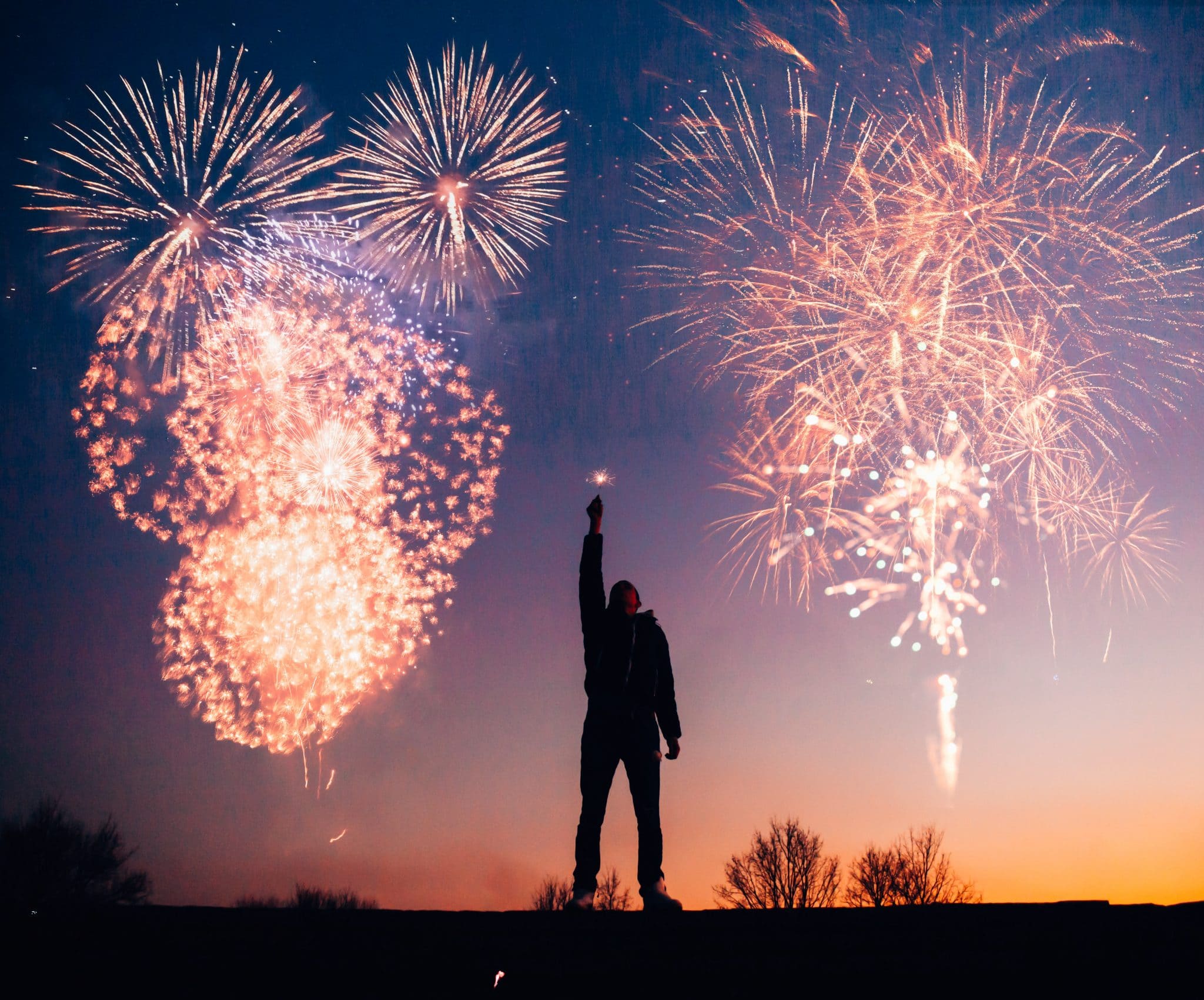 Man with fireworks in his hand and fireworks in the air