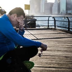 Man holding his hand to his face while he suffers from fatigue