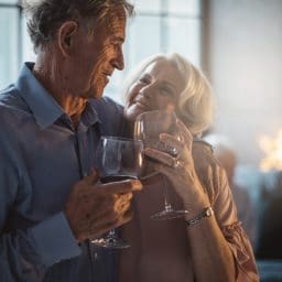 Two older adults enjoying a glass of wine