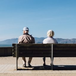 Older couple sitting on a bench.