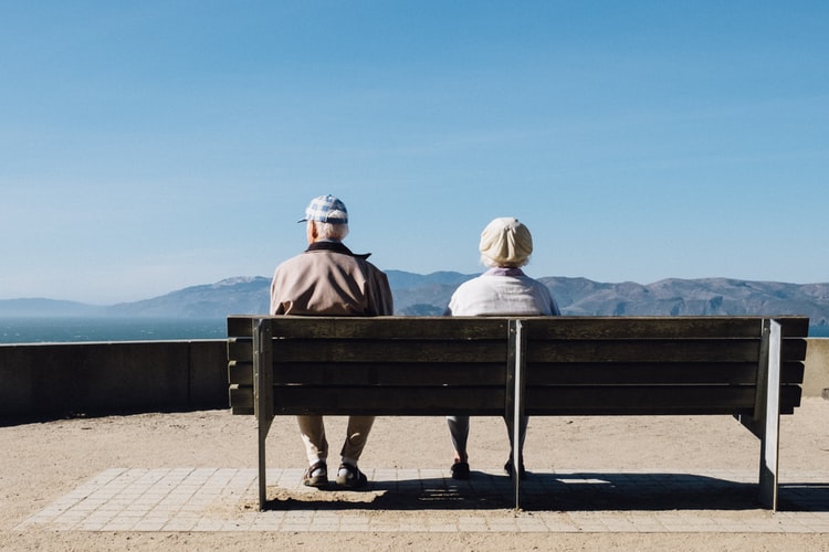 Older couple sitting on a bench.