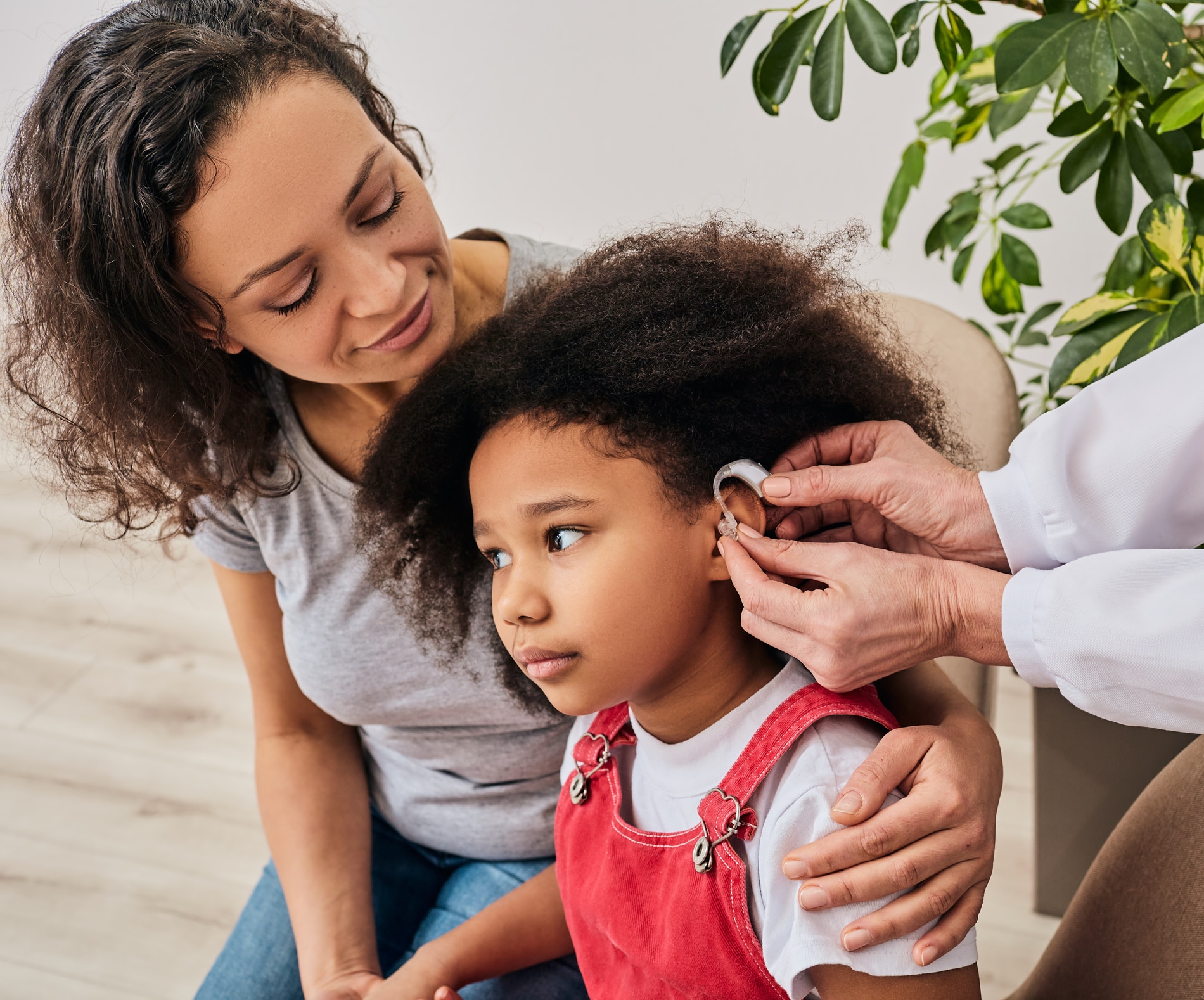 Little girl with her mother going in for a hearing aid fitting.
