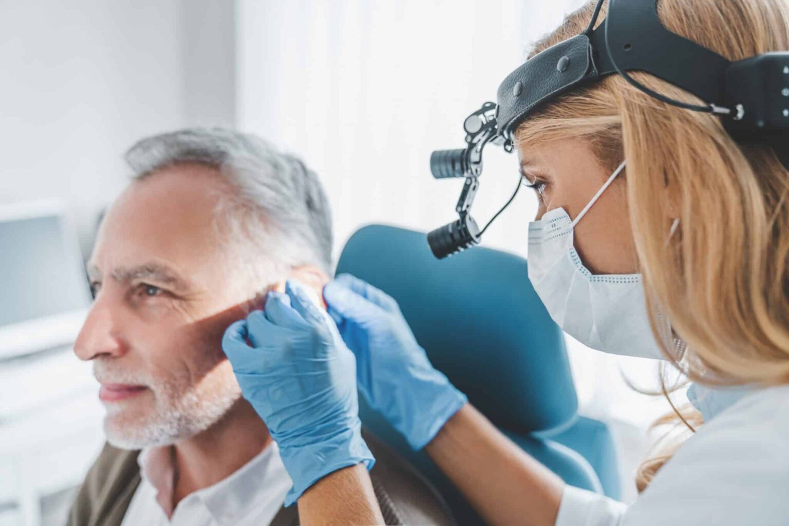 Older man getting an ear exam.