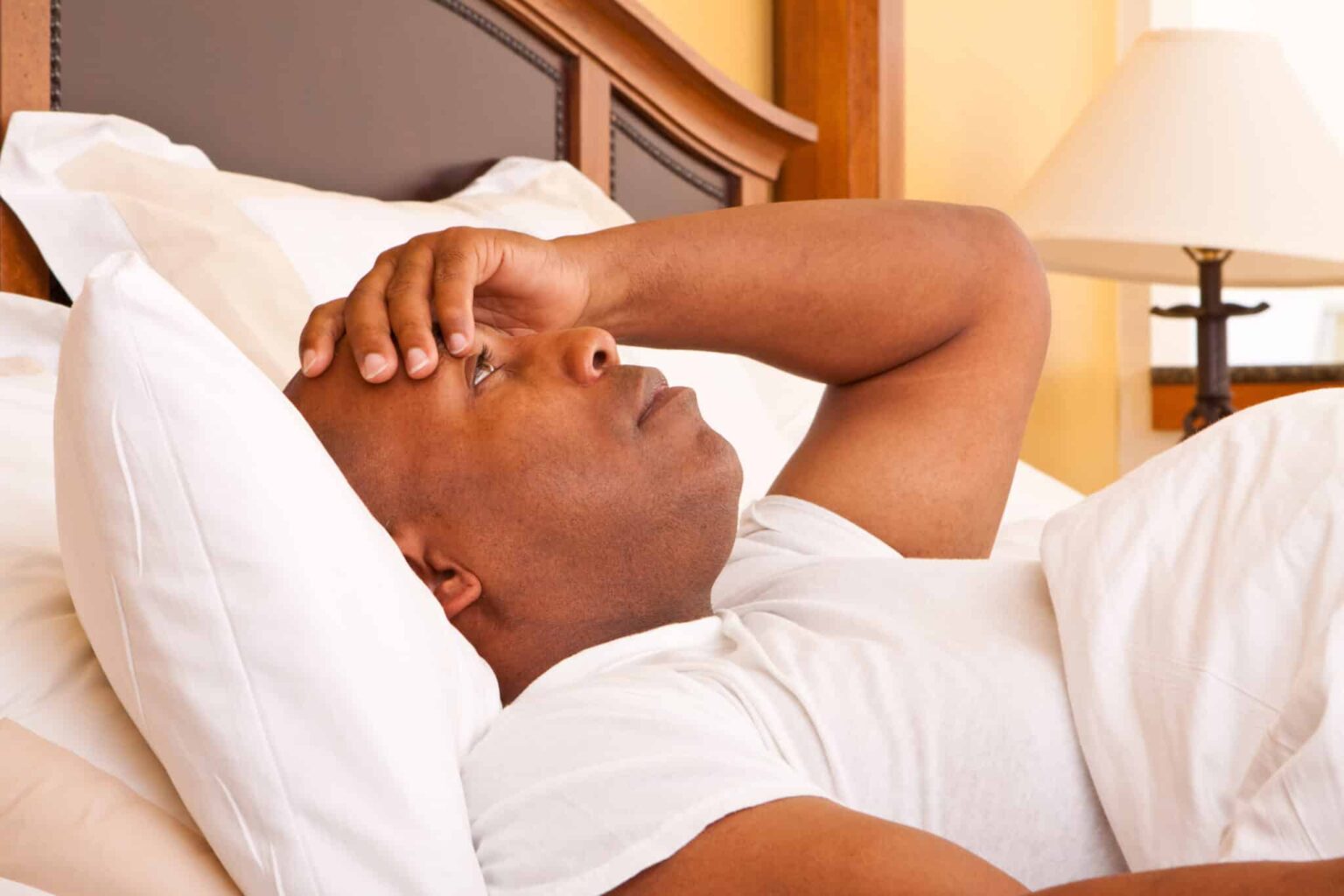 Man with insomnia lying awake in bed.