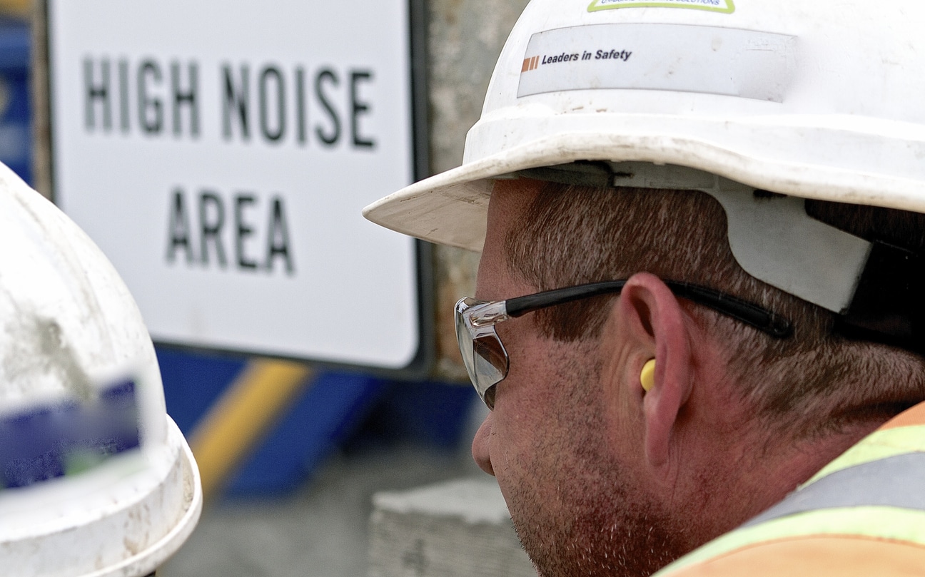 Man at construction site wears earplugs Man at construction site wears earplugs