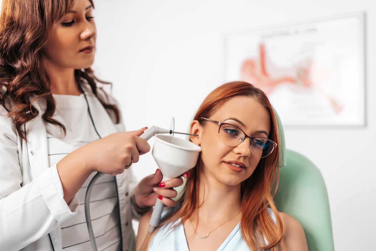Earwax Removal ENT removing a woman's earwax with irrigation.