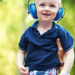 Child with APD wearing earmuffs