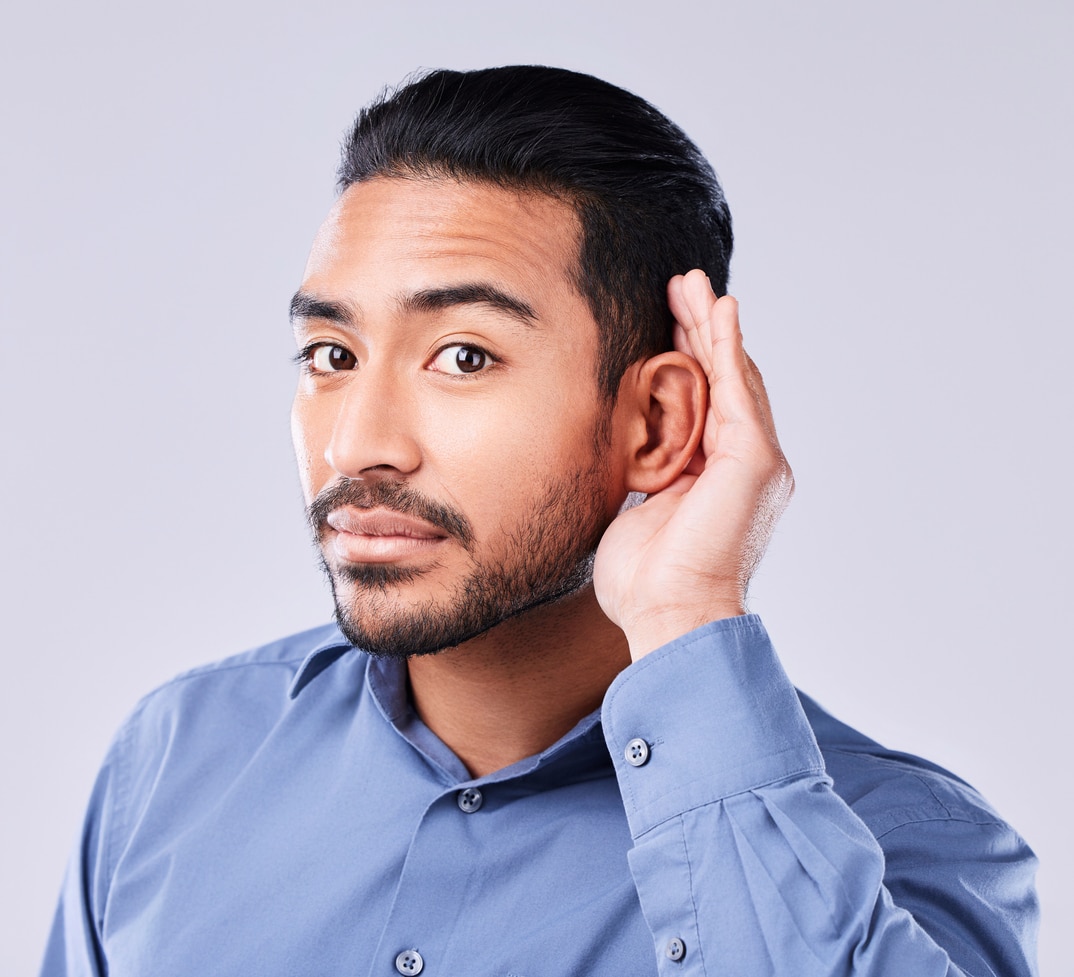 Man with hearing loss holding a hand up to his ear. Man with hearing loss holding a hand up to his ear.